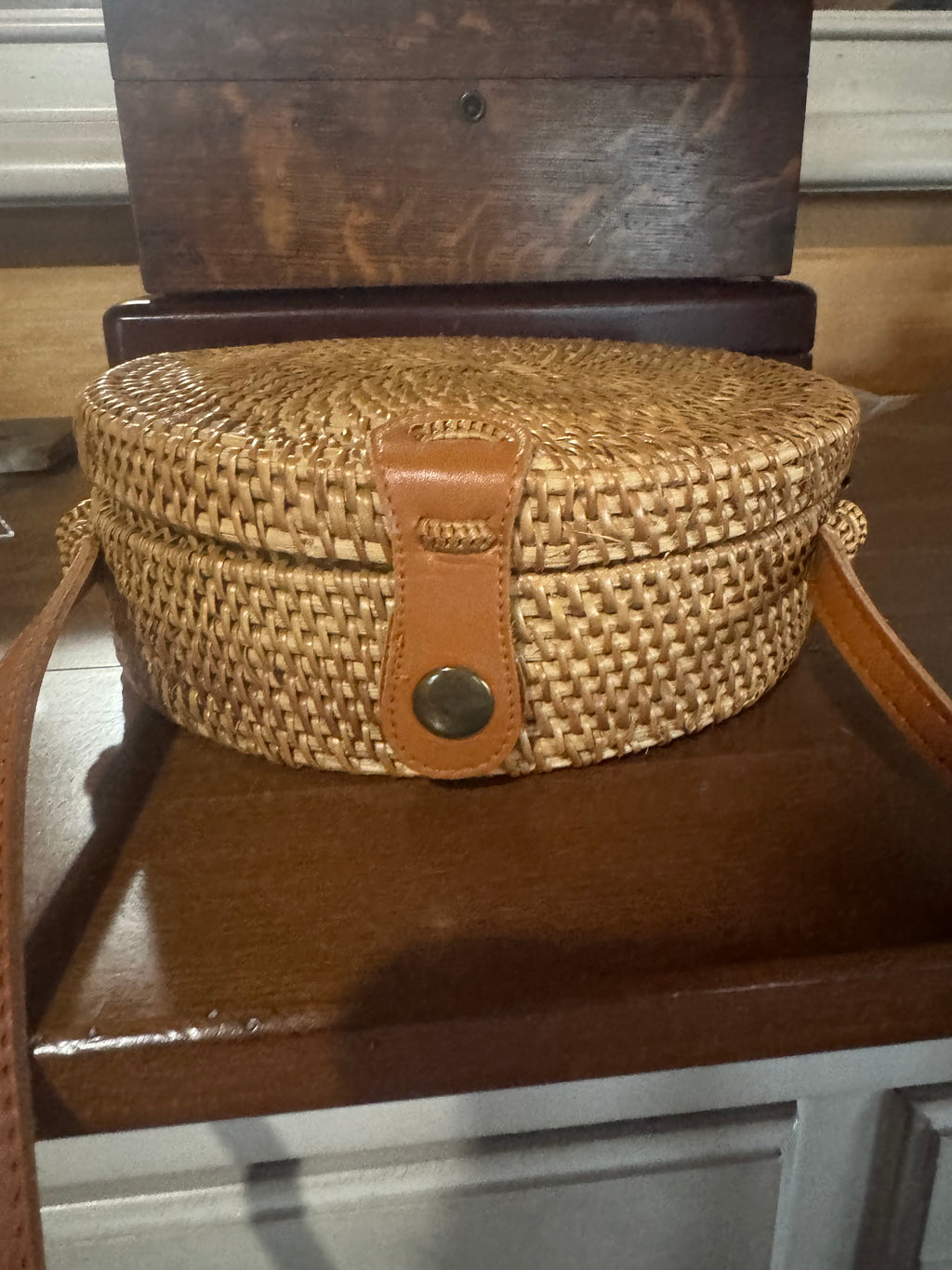 Vacation ready round woven straw crossbody with leather strap