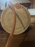 Vacation ready round woven straw crossbody with leather strap